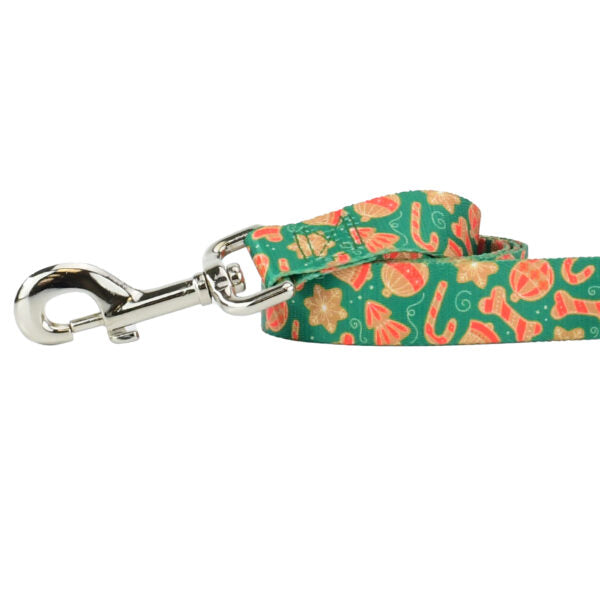 Close-up of dog leash with silver hardware featuring colorful cookie shapes on green background by Primemarket7 - Earthstyle